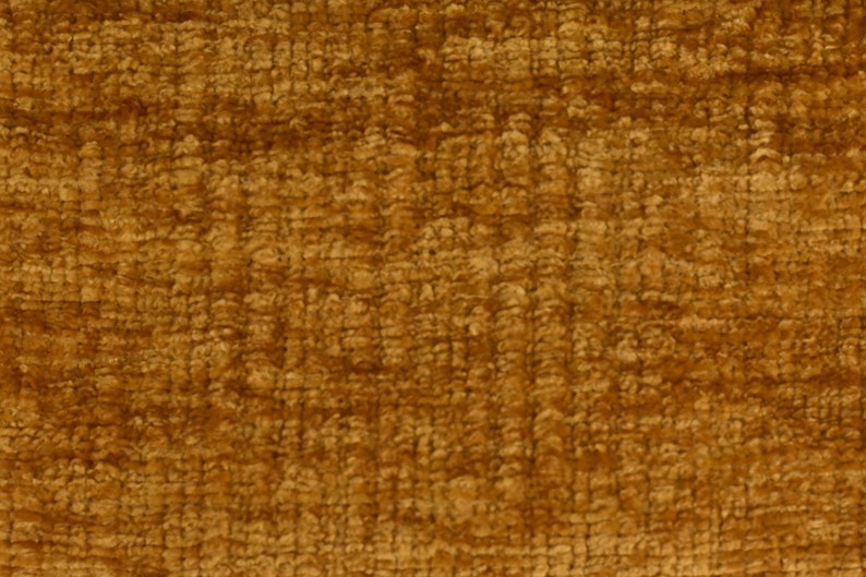 May include: Close-up of a textured fabric in a deep golden brown colour. The fabric has a slightly fuzzy texture.