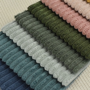 May include: A stack of different coloured corduroy fabrics. The fabrics are arranged in a gradient from dark blue to light yellow.