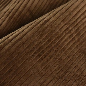 May include: Close-up of brown corduroy fabric with a subtle texture and a diagonal pattern.