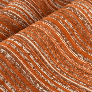 Könnte beinhalten: Nahaufnahme eines strukturierten Stoffes mit orangefarbenen und weißen Streifen. Der Stoff hat eine gewebte Optik und ein leicht gewelltes Muster.