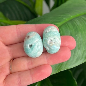 May include: Two smooth, light blue and white, green aventurine tumbled stones.