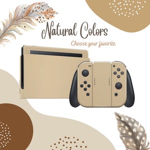 以下が含まれることがあります： 黒のアクセントが付いたベージュのNintendo Switch本体とコントローラー。本体とコントローラーは、茶色とベージュの抽象的な形と羽根が描かれた白い背景の上に置かれています。本体の上に「Natural Colors」と「Choose your favorite」というテキストが表示されています。