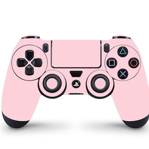 May include: A pink PlayStation 4 controller with black buttons and a black PlayStation logo.