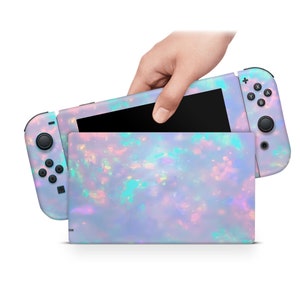 May include: A Nintendo Switch console with a custom skin featuring a pastel opal design. The console is closed and the Joy-Con controllers are attached.
