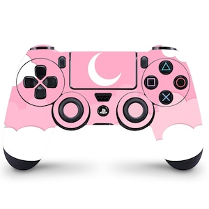 Op de afbeelding: Een roze PlayStation 4-controller met een wit halve maan- en wolkendesign.
