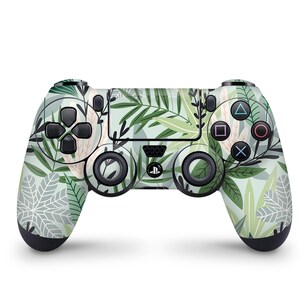 May include: A black PlayStation 4 controller with a green and white tropical leaf pattern.