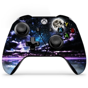 May include: A black Xbox controller with a custom skin featuring a dark night sky with a full moon, stars, and a silhouette of a tree. The controller has a purple and blue glow emanating from the horizon.