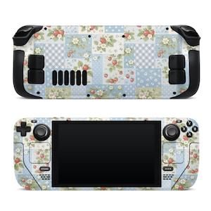 May include: A handheld gaming console featuring a skin with a patchwork pattern of light blue, white, and green squares. The design includes illustrations of red strawberries, white flowers, and green leaves, along with polka dot and gingham check textures.