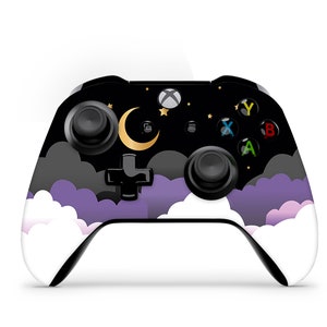 Puede incluir: Un mando Xbox negro con un diseño personalizado que presenta una luna creciente, estrellas y nubes en tonos de morado y blanco.