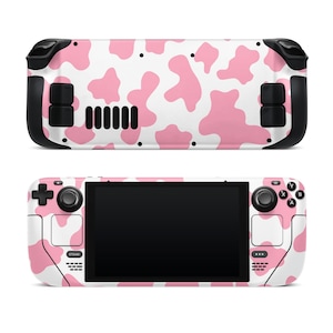 May include: A pink and white cow print skin for a handheld gaming console. The skin covers the front and back of the console, including the buttons and joysticks.