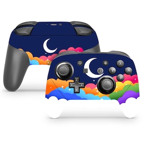 Op de afbeelding: Een blauwe en witte Nintendo Switch controller skin met een halve maan en regenboogwolken ontwerp.