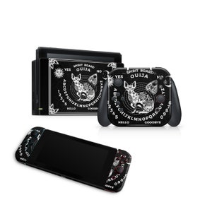 May include: A black Nintendo Switch console and controller with a white and black Ouija board design featuring a cat and the words "Spirit Board Ouija".
