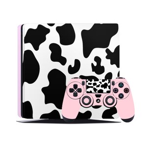May include: A pink PlayStation 4 console and controller with a black and white cow print design.