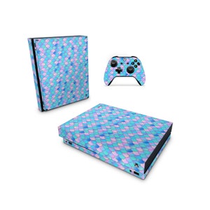 Könnte beinhalten: Ein blauer und lilafarbener Aufkleber mit Meerjungfrauen-Schuppenmuster für eine Xbox Series X Konsole und einen Controller.