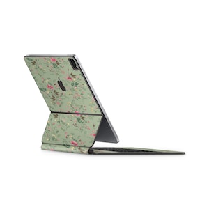 May include: A green floral iPad case with a matching keyboard. The case features a delicate floral pattern with pink and white flowers on a green background.