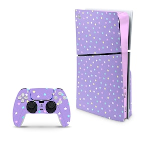 May include: A purple PlayStation 5 console with a pink and white star pattern skin. The console is next to a purple PlayStation 5 controller with a pink and white star pattern skin.