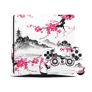 May include: A white PlayStation 4 console and controller with a black and white Japanese-inspired design featuring a cherry blossom tree and a pagoda. The design is painted in a watercolor style.