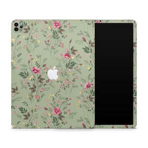 May include: A green iPad case with a floral pattern featuring pink flowers and green leaves. The case has a cutout for the camera and a black screen.