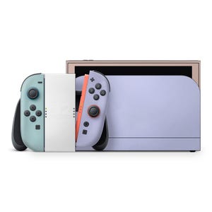 Könnte beinhalten: Eine hellviolette und weiße Nintendo Switch-Konsole mit zwei abnehmbaren Controllern in Türkis und Lila. Die Controller haben schwarze Knöpfe und Joysticks. Die Konsole befindet sich auf weißem Hintergrund.
