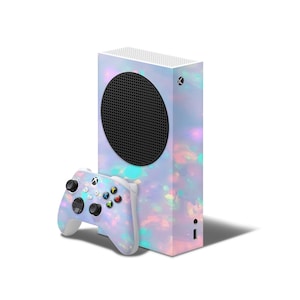 May include: A gaming console and controller set with a colorful, iridescent design. The console is a vertical rectangle with a large black circular vent. The controller has colored buttons and a white base.