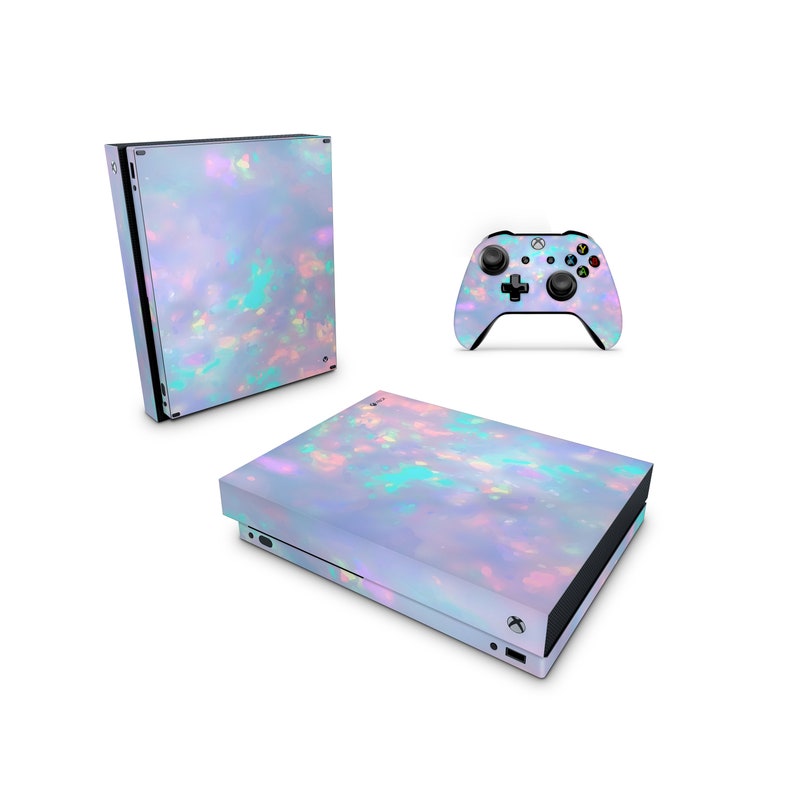 Puede incluir: Una consola Xbox Series X blanca y un mando con un dise&ntilde;o de &oacute;palo iridiscente. La consola tiene una superficie texturizada y el mando tiene una superficie lisa.