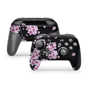 May include: A black Nintendo Switch controller with a pink and white cherry blossom design.