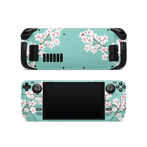 May include: A handheld gaming console featuring a teal background adorned with a cherry blossom design. The console has black controls and a black screen. The floral pattern is present on both sides of the device.