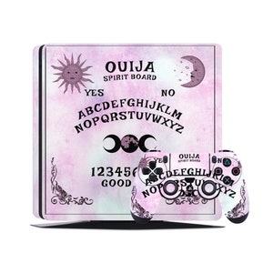 May include: A pink and white PlayStation 4 console and controller with a pink and white Ouija board design. The design features a sun, moon, and the letters of the alphabet. The text "Ouija Spirit Board" is printed on the console.