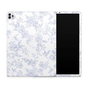 May include: A white tablet case featuring a blue floral and bird pattern. The design includes detailed illustrations of flowers, leaves, and flying birds, creating a classic, elegant aesthetic. The tablet's screen is black.