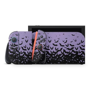 May include: A Nintendo Switch console and controllers featuring a purple and black bat pattern. The controllers have black buttons and orange rails. The console has a black screen.