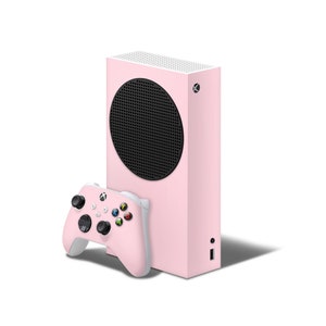 Può includere: Una console Xbox Series X rosa con una griglia dell'altoparlante nera e un controller Xbox bianco.