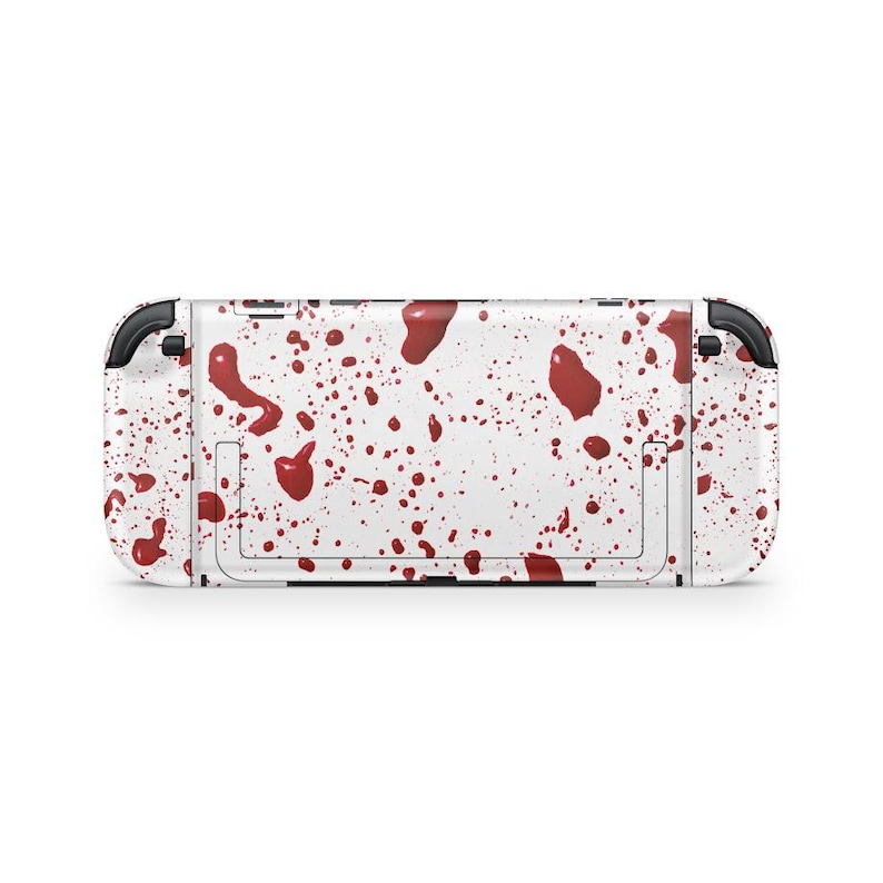 May include: A white Nintendo Switch console with a pattern of red blood splatters. The console has black accents on the sides and a kickstand on the back. The design covers the entire console.