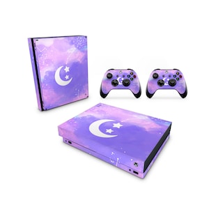 Puede incluir: Una piel de consola Xbox Series X con temática de galaxia púrpura y rosa con una luna creciente blanca y estrellas. La piel también está disponible para dos mandos Xbox.