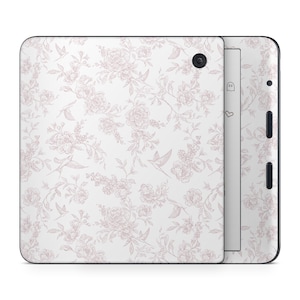 May include: An e-reader device featuring a white skin with a delicate, light pink line-art pattern of blooming flowers and small birds. The device has a black circular button on the top right corner and black side buttons on the right edge.