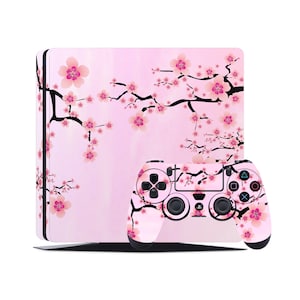 以下が含まれることがあります： 桜の花柄のピンクとブラックのPlayStation 4本体とコントローラーです。