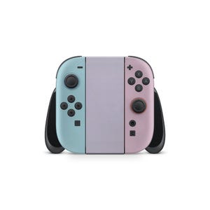 May include: A pastel-coloured Nintendo Switch console. The left Joy-Con is light blue, the right is pink, and the centre is lavender. Black control sticks and buttons are visible. The console is designed for handheld or docked gaming.