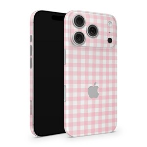 May include: A pink and white gingham patterned phone case with a black phone. The case has a camera and the Apple logo. The phone is black.