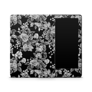 May include: Black and white floral pattern on a Kindle Paperwhite e-reader case. The case has a black background with white roses and leaves.