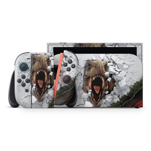 May include: A Nintendo Switch console and controllers with a dinosaur theme. The design features a realistic Tyrannosaurus Rex breaking through a white, cracked wall. The controllers have black buttons and orange accents.