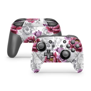 May include: A white Nintendo Switch controller with a floral and skull design. The controller has pink and purple flowers, gray skulls, and a white background.