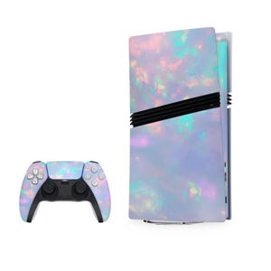 Puede incluir: Una consola de juegos blanca e iridiscente con un mando a juego. La consola tiene un diseño texturizado, similar al ópalo, con toques de rosa, azul y verde.