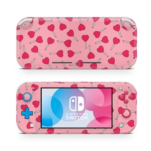 May include: Pink Nintendo Switch Lite console with a pink and white heart lollipop pattern. The console has blue buttons and a white Nintendo Switch logo.