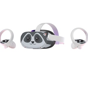May include: A VR headset with a raccoon face design, featuring a white strap and two white controllers. The headset is primarily grey and black, with a purple accent on top. The controllers have black and grey buttons.