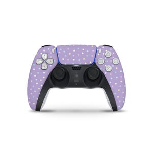 May include: A lavender game controller with a pattern of small, colorful stars. The controller has black accents and buttons, with a blue strip along the top. The directional pad and buttons are white.