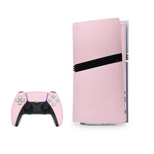 Pode incluir: Um console PlayStation 5 rosa com um controle rosa correspondente. O console está em pé e o controle está deitado sobre uma superfície branca.