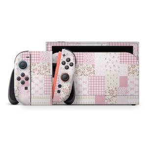 Puede incluir: Una consola de videojuegos y dos mandos con una funda de patchwork en tonos rosa y blanco. El diseño incluye varios patrones como cuadros vichy, estampados florales y pequeños lazos, cubriendo toda la superficie de la consola y los mandos.