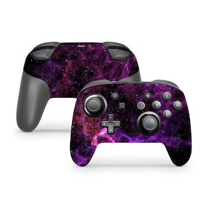 May include: A purple and black Nintendo Switch controller with a galaxy design. The controller has a black faceplate with a purple and black galaxy design. The controller has a black faceplate with a purple and black galaxy design.