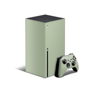 Op de afbeelding: Een saliegroene Xbox Series X-console en bijpassende controller. De console is een hoge, rechthoekige toren met een zwart ventilatierooster aan de bovenkant. De controller heeft zwarte accenten en meerdere knoppen.