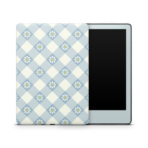 May include: A blue and white checkered pattern with small white flowers and yellow centers covers the front of a Kindle e-reader case.