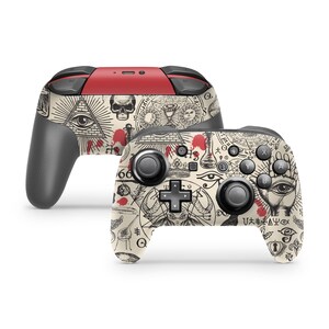 May include: A black and white patterned Nintendo Switch controller with red blood splatter accents. The pattern features an all-seeing eye, a pyramid, and other occult symbols.